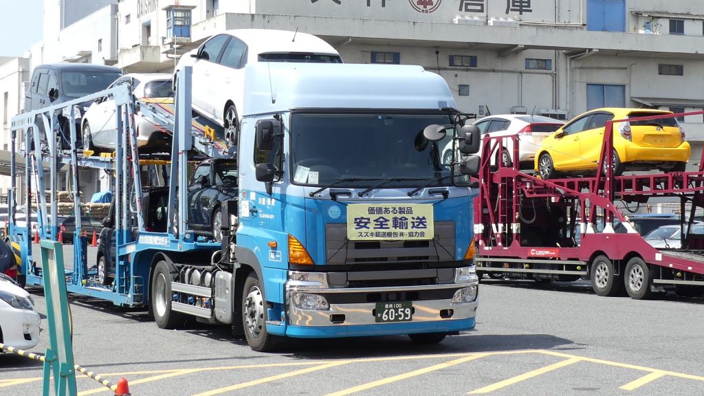 Car carrier trucks offloading at Japanese car auction